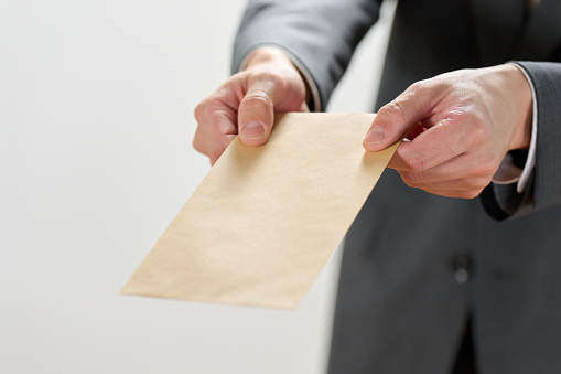 Businessman holding out an envelope