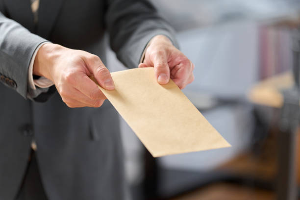 istock Businessman holding out an envelope 1992079100