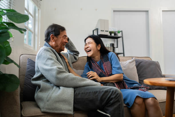 istock Older couples sit and chat and head over each other relaxed and happy on sofa at home on weekday in comfortable 1992079631
