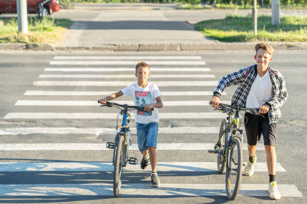 istock Two boys crossing pedestrian crosswalk with bicycles 1992081699
