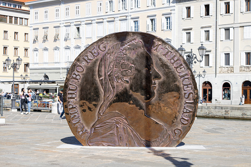 Trieste, Italy - September 26, 2023: Monument to the Austrian Thaler (thaler of Maria Teresa), great coin located on Ponterosso Square over Grand Canal