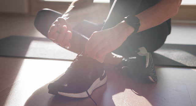 Fitness enthusiast ties shoelaces, getting ready for exercise session