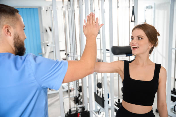 istock Physiotherapist greeting female patient in gym 1992121754