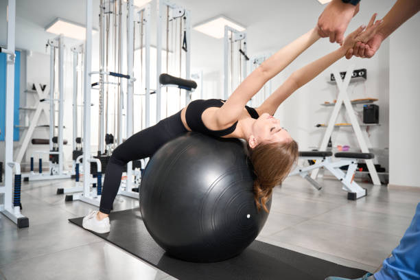istock Beautiful woman performs muscle stretching exercises with a fitball 1992122310