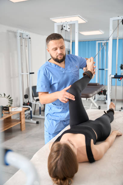 istock Physiotherapist uses a special exercise machine to work with patient 1992123515