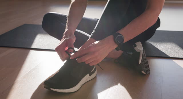 Fitness buff secures shoelaces for workout
