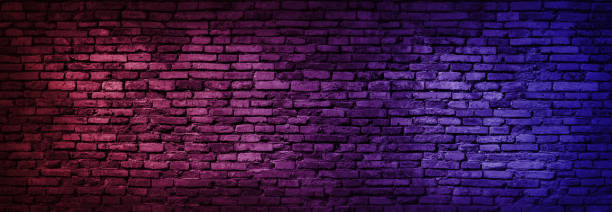 istock Neon light on brick walls that are not plastered background and texture. Lighting effect red and blue neon background of empty brick basement wall. 1992134628