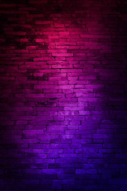 istock Neon light on brick walls that are not plastered background and texture. Lighting effect red and blue neon background of empty brick basement wall. 1992144130