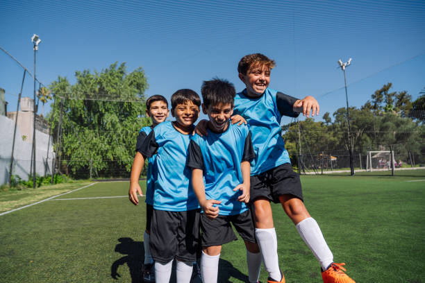 istock Cheerful Young Soccer Team Celebrating on the Field in Uniforms 1992145176