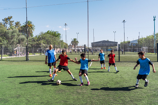 A diverse team of young athletes engaged in a passionate soccer match on a sunny day outdoors.