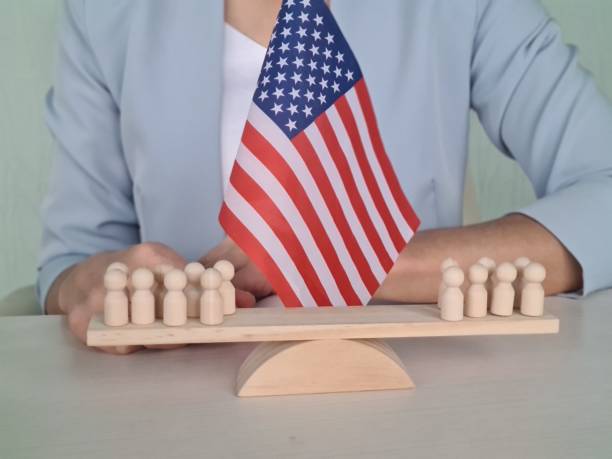 istock Balancing Diversity Wooden People on Scale with American Flag for Unity and Equality Concept 1992154740