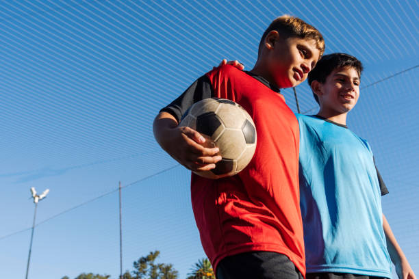 istock Young Friends Enjoying Soccer Game Break on Sunny Day 1992154742