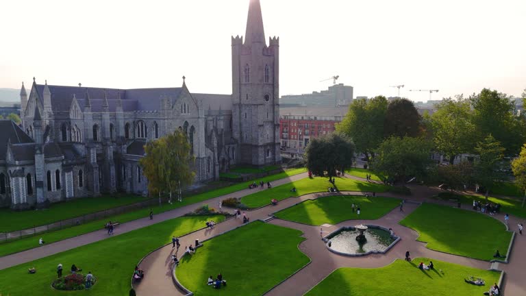 Aerial view of cathedral and park from Saint Patrick's Park-Dublin, Aerial view of historic St. Patrick's Cathedral in the heart of Ireland, Christ Church Cathedral, Aerial view of people walking in saint Patrick park, Public park fountain