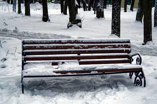 Outdoor bench in the snow in the park, Moscow