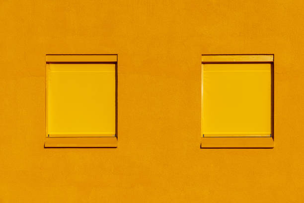 Germany, Berlin - January 29, 2024 - Full frame of two yellow windows on a yellow house wall, Berlin Tempelhof
