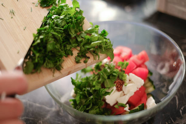 vegetable salad of cucumbers, tomatoes, parsley, dill, spinach, basil, cilantro, arugula close-up