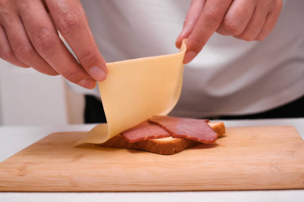 istock woman preparing toast with cheese and ham close up 1992201673
