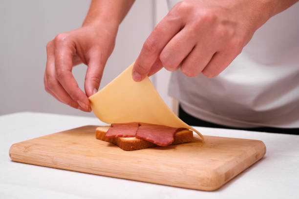 istock woman preparing toast with cheese and ham close up 1992201674