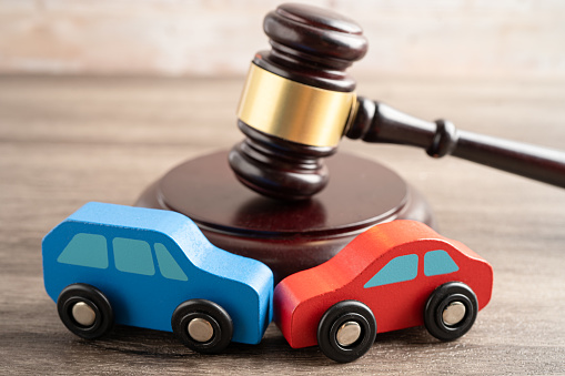 Hammer gavel judge with car vehicle accident, insurance coverage claim lawsuit court case.