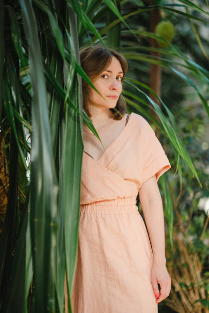 istock Woman standing among tropical plants 1992217647