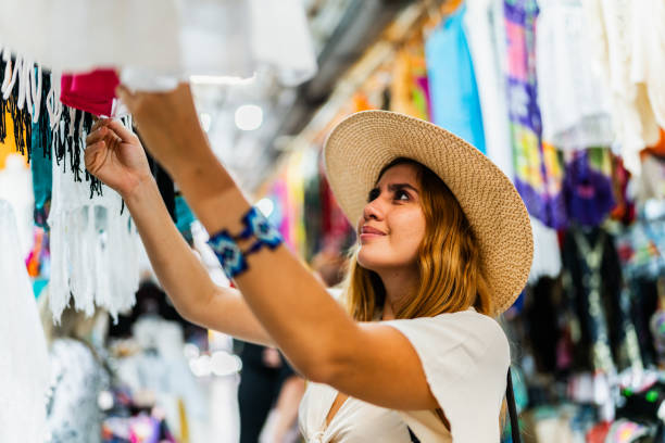 istock Young woman looking clothes at market 1992219764