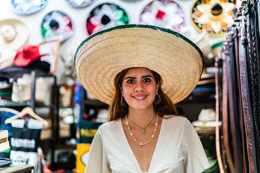 Portrait of a young customer woman using a sombrero at store