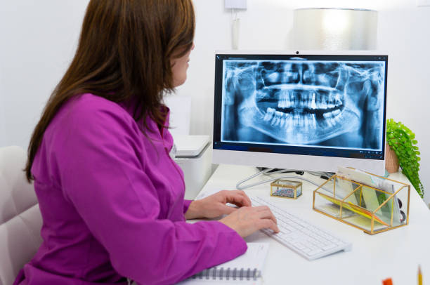 istock Female dentist in her office looking at an x-ray on her computer 1992227784