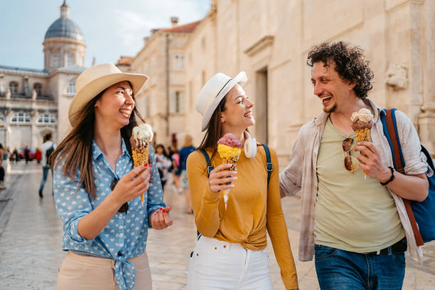 istock Three Young Friends Eating Ice Cream While Walking On The Street Dubrovnik 1992228321