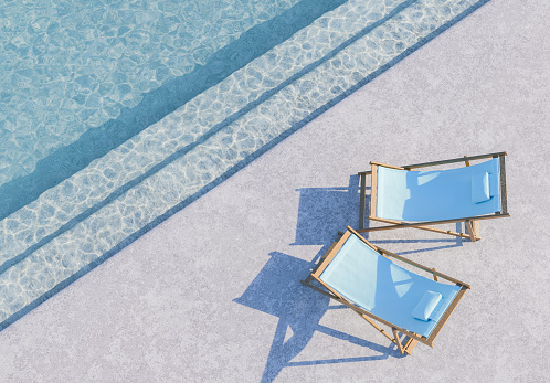 3d rendering of two blue lounge chairs beside a swimming pool casting shadows on the concrete deck under the bright summer sun. Relaxation and resort concept.