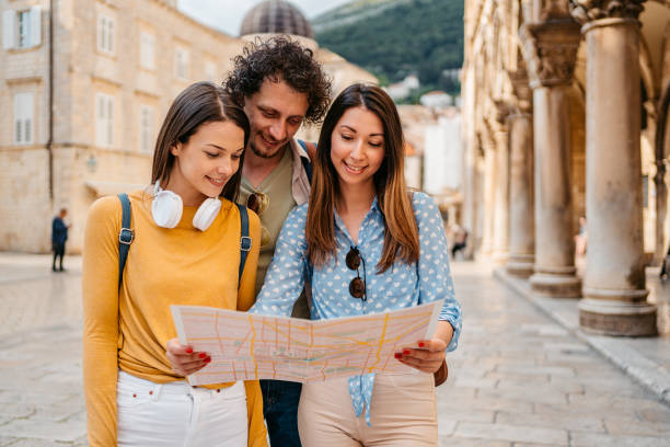 istock Three Young Friends Reading A Map On The Street In Dubrovnik 1992234767