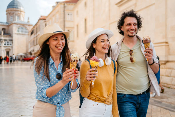istock Three Young Friends Eating Ice Cream While Walking On The Street Dubrovnik 1992237979