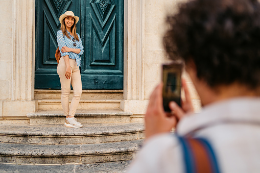 Female freelance photographer walking with camera around tourist place.
