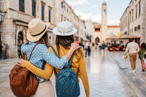 Two young female tourists embracing on the street in Dubrovnik in Croatia.