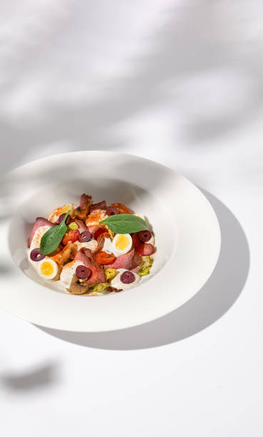 istock Roast Beef Salad with Quail Eggs and Vegetables on Shadowed White Presentation 1992247538
