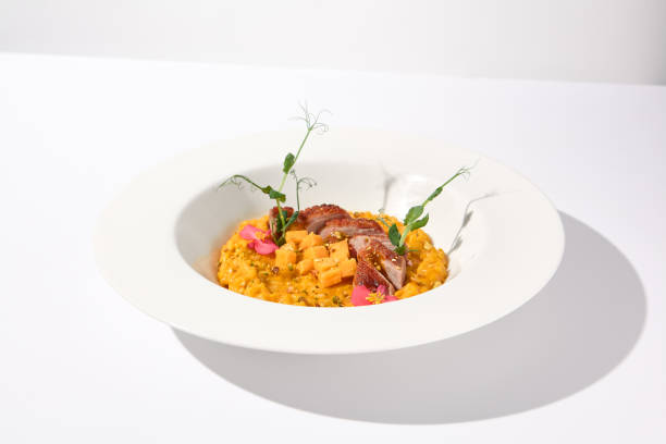 istock Duck breast with pumpkin risotto on a white plate, a gourmet meal for fine dining and restaurant menus 1992247554
