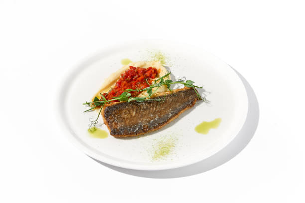 istock Pan-Seared Trout Fillet with Potato Puree and Tomato Salsa on White, a Fresh Take on Classic Seafood Dishes 1992247573