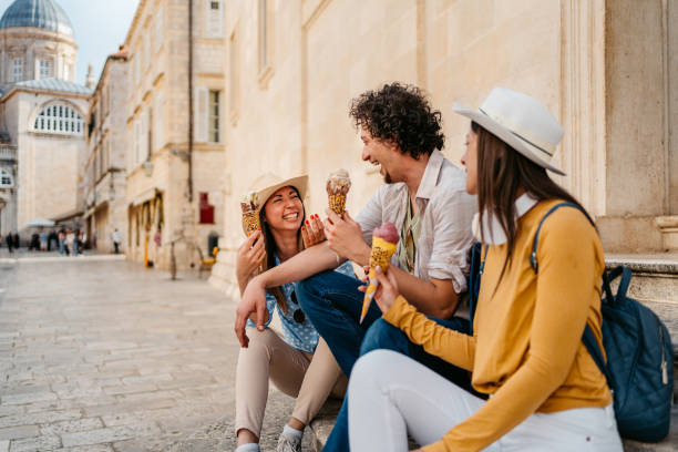 istock Three Young Friends Eating Ice Cream While Sitting On The Steps In Dubrovnik 1992256421