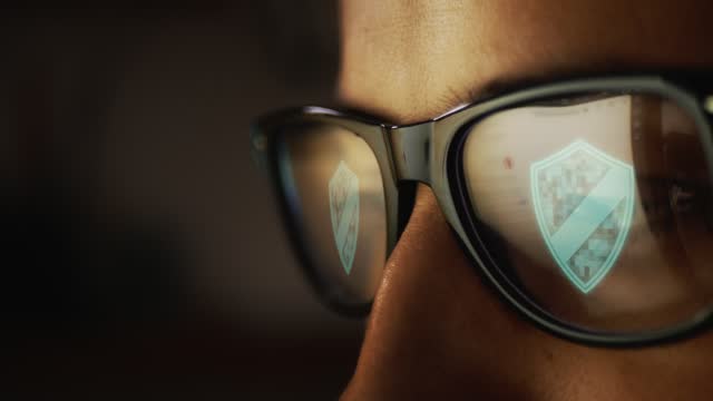 Cg footage, double reflection in glasses against the background of eyes, search for pages on the Internet and digital symbol of information protection. Male face. Hacker. Spy. Programmer