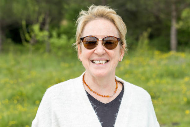 Portrait of a happy smiling mature blonde woman . Cheerful senior adult female beautiful person smile looking at camera close up stock photo