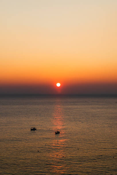 Sea sunrise landscape. Sunlight reflecting on the sea surface and a ship passing between it