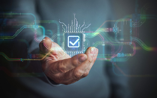 Digital agreement technology in your hand. Male hand holding futuristic check mark icon in the center and circuit board with vibrant data transfers, representing evolving assistance technology of the future.