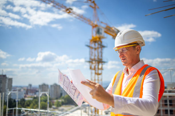 istock Caucasian building contractor looking at the blueprint on the construction site 1992277540