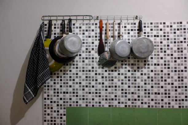several cooking utensils hanging on the kitchen wall.