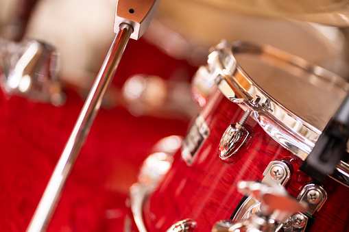 Complete set of red drums in studio, bokeh light background.