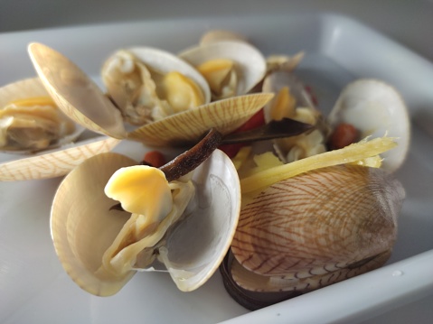 A bowl of fresh steamed clams with fresh basil and red pepper flakes