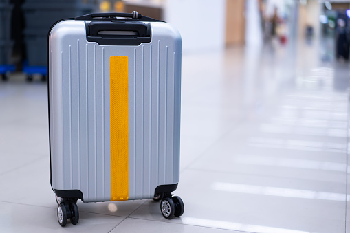 Stylish travel bag In an empty airport hall, the suitcases of vacation travelers.