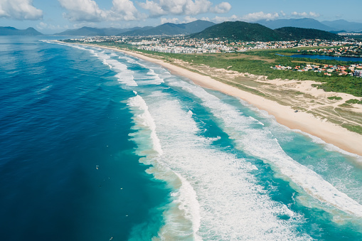 Scenic beach and ocean with surfing waves in Brazil. Aerial view of Campeche beach