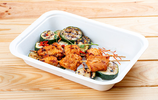 Grilled chicken kebab with zucchini. Healthy diet. Takeaway food.  On a wooden background.