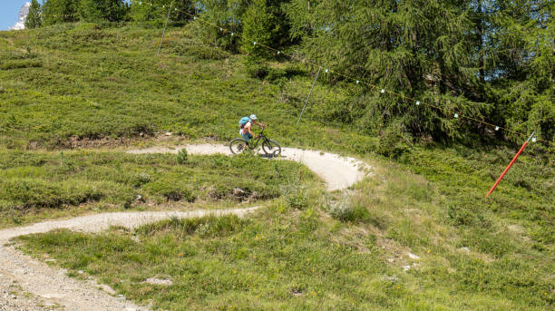 istock Fermale mountain biker descends path in the forest 1992306304