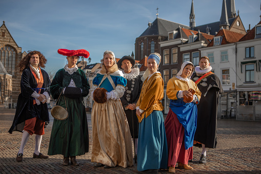 A group of seven traditionally dressed male and female tourist guides in Delft on a spring day